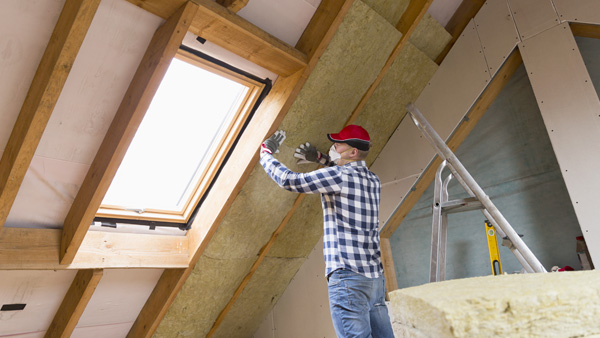 Man installing attic insulation