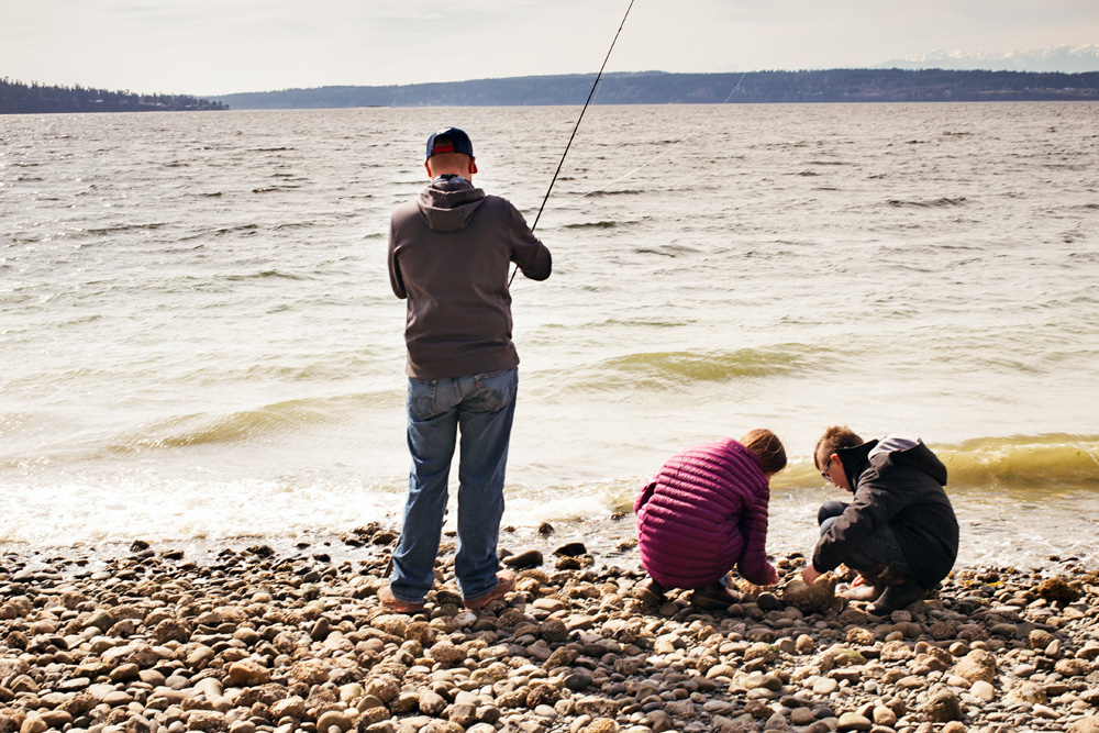 Father and children fishing and collecting shells